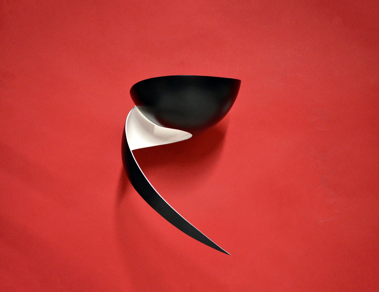Black Serge Mouille Flame Sconce on red wall