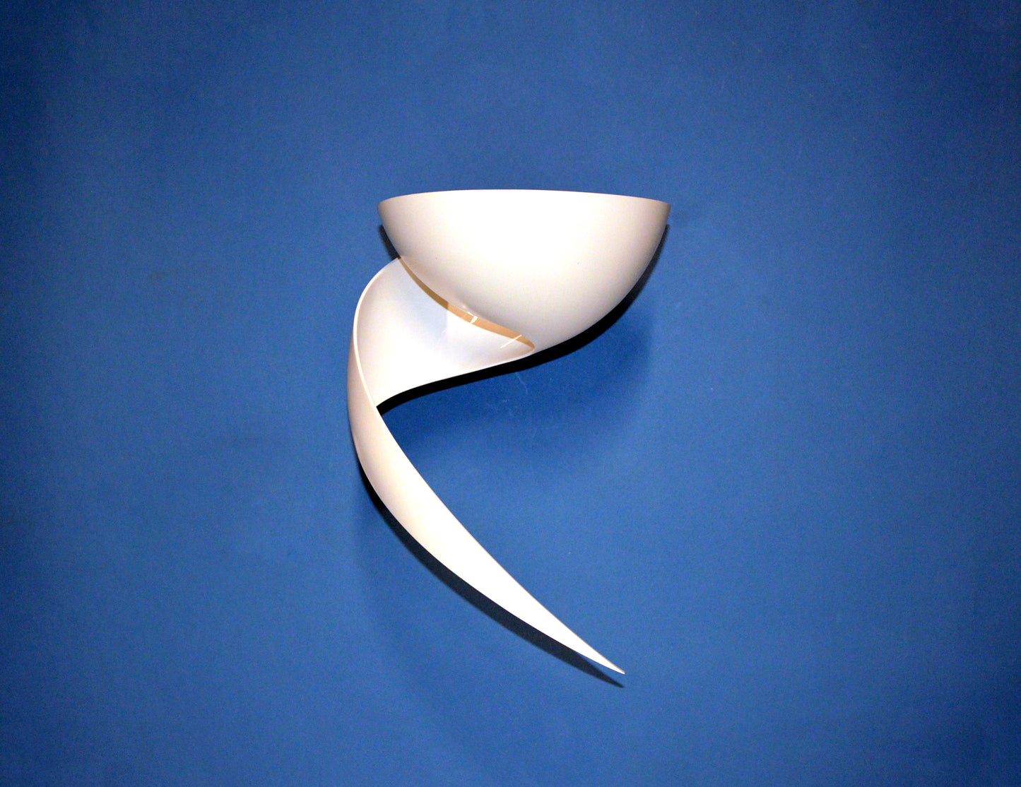 White Serge Mouille Flame Sconce on dark blue wall