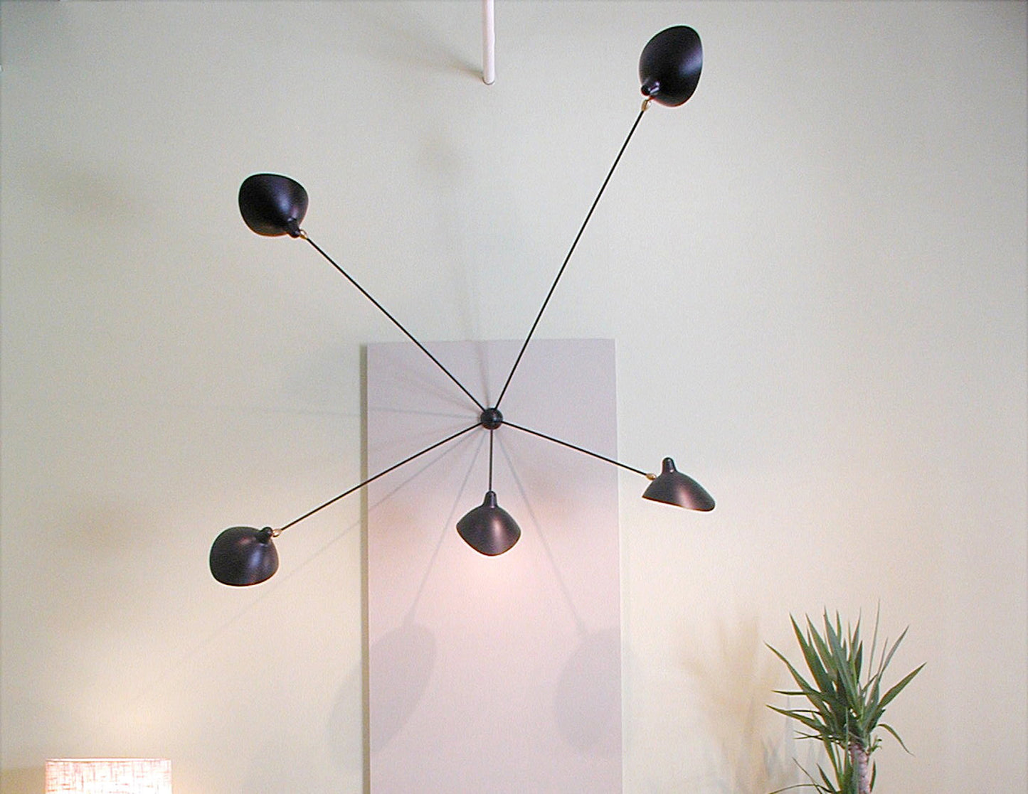 Black Serge Mouille Spider Sconce with 5 Arms on a white wall