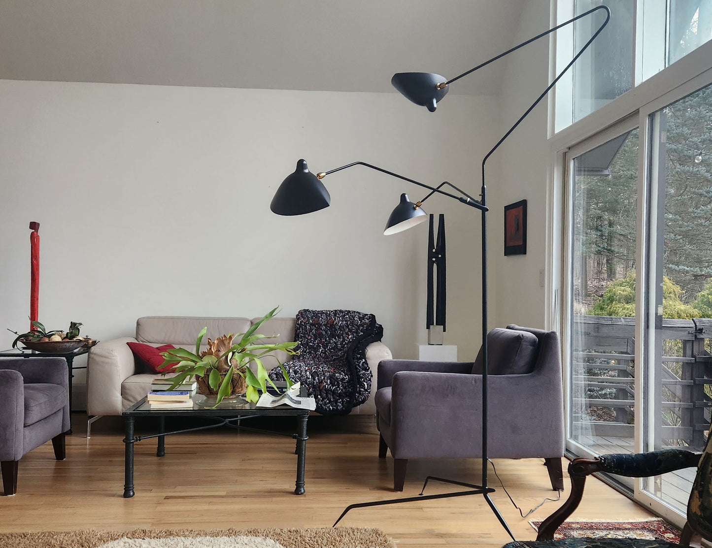 Black Serge Mouille Floor Lamp with 3 Arms shown in a living room